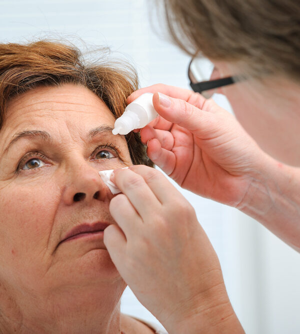 Senior woman applying eye drops