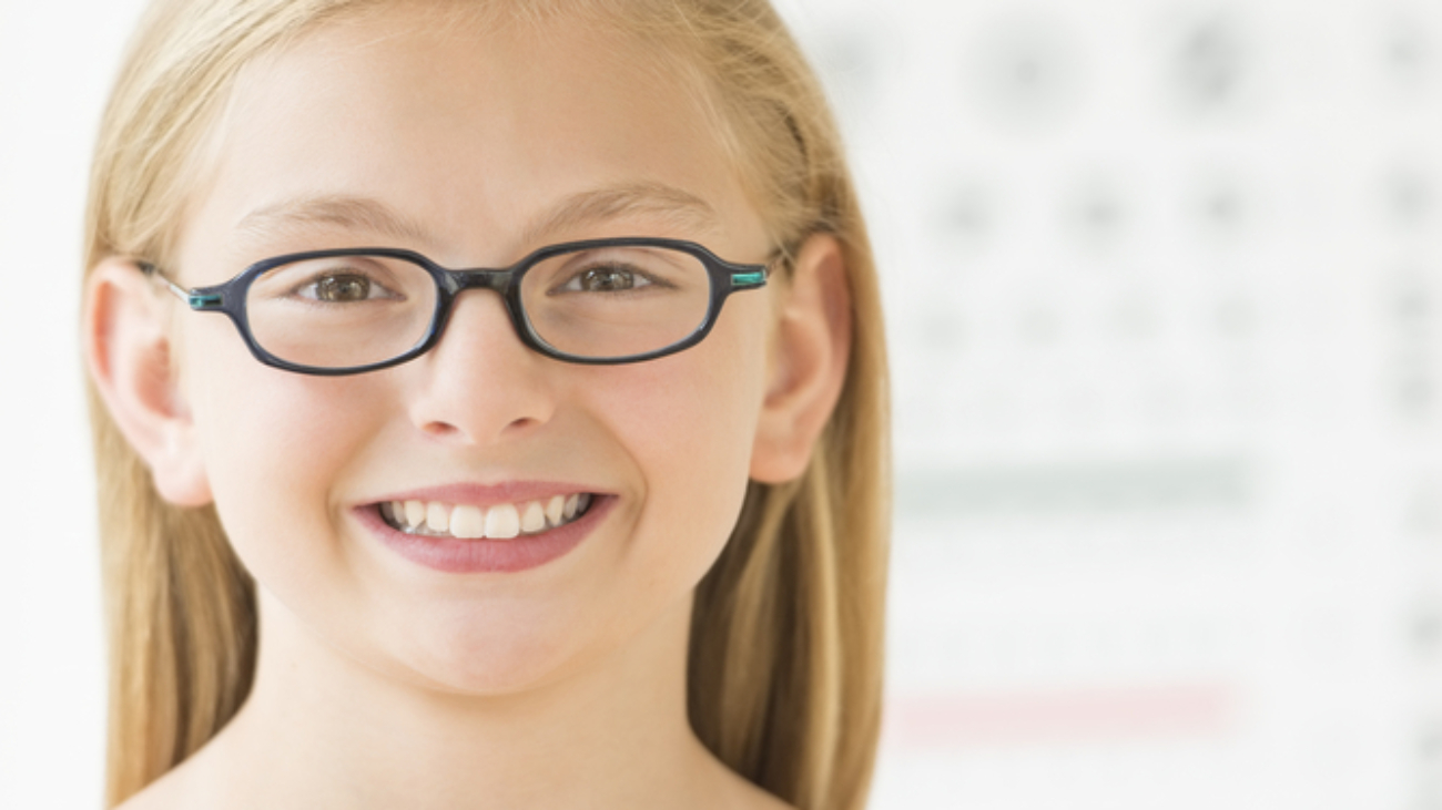 Confident Girl Wearing Glasses Against Eye Chart