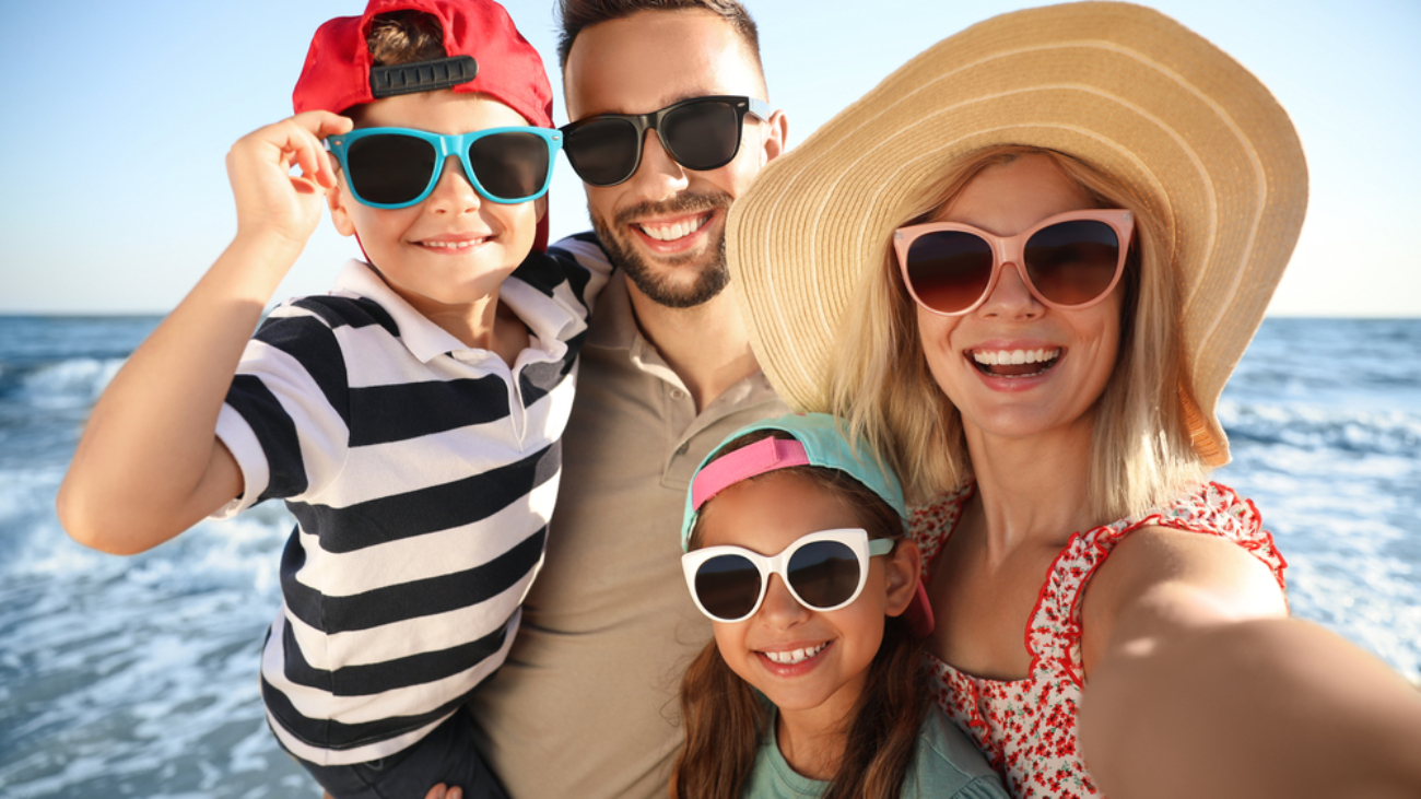 Happy family taking selfie on beach near sea. Summer vacation