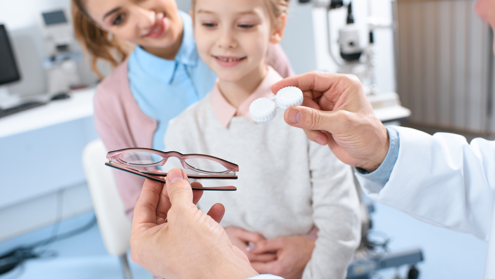 young childs in eye exam room geting fitted for contacts and glasses. Is my child ready for contacts.