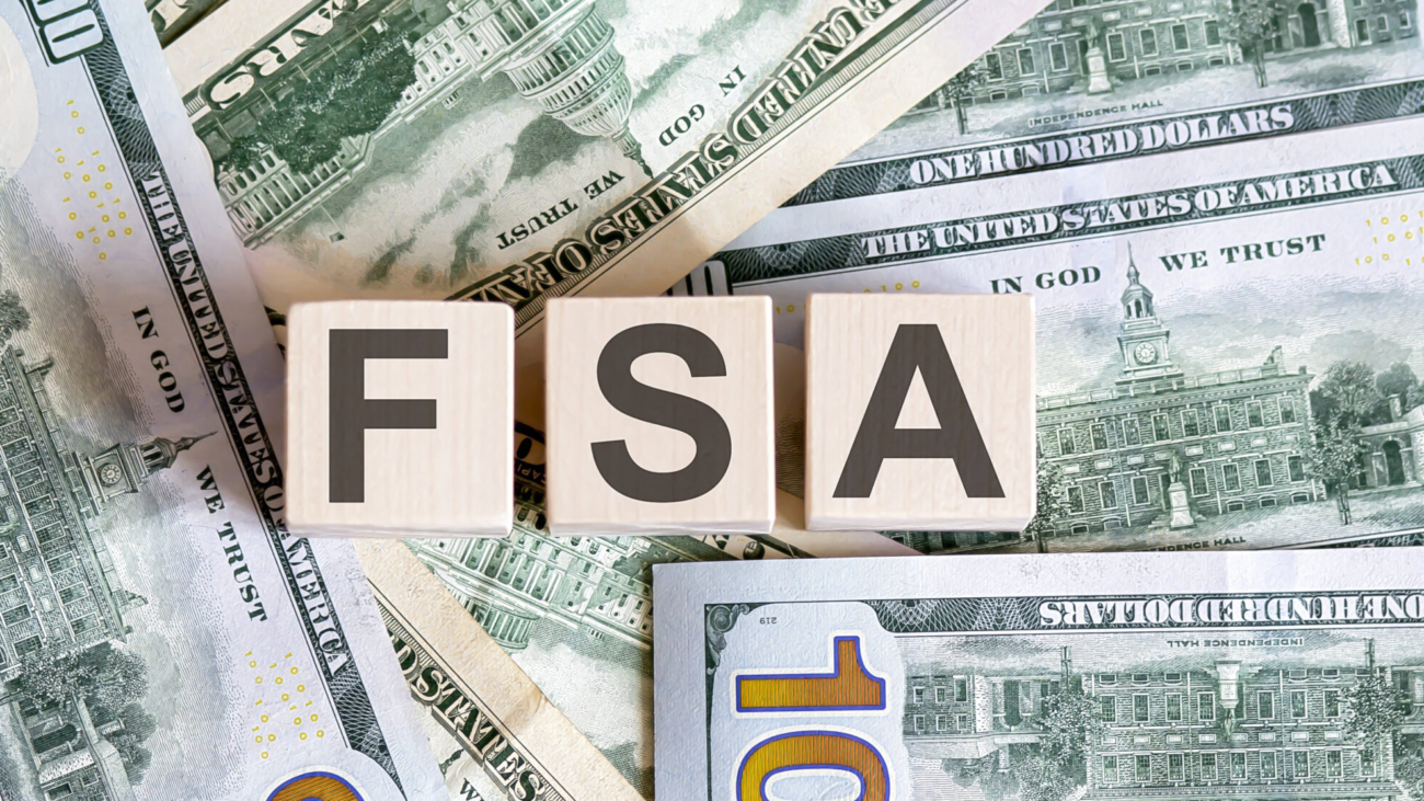 image of US money sprawled out with block letters FSA on top representing 2024 FSA benefits