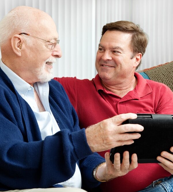 Senior father and adult son viewing a tablet pc -