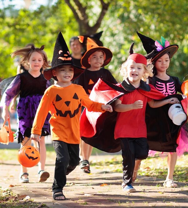 Kids trick or treating on a fall street. Halloween fun for children.