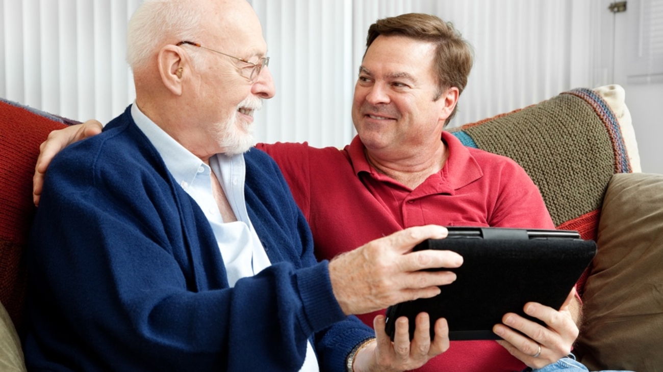 Senior man using tablet PC with his adult son.
