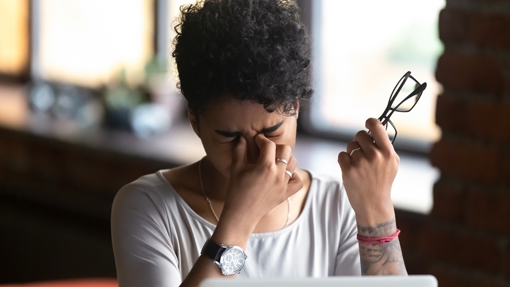 African American woman taking off glasses, feel eye strain, massaging nose bridge, tired female feeling discomfort after long wearing glasses at workplace, work with computer, bad eye vision close up