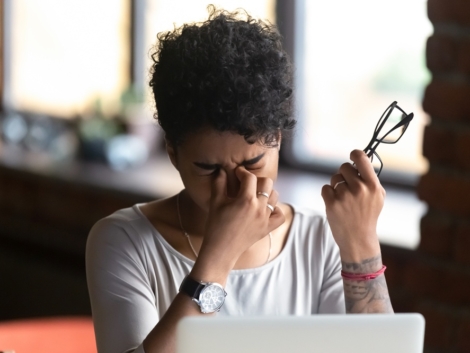 African American woman taking off glasses, feel eye strain, massaging nose bridge, tired female feeling discomfort after long wearing glasses at workplace, work with computer, bad eye vision close up