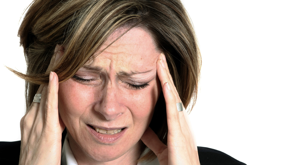 Women holding her temples with a facial expression of pain