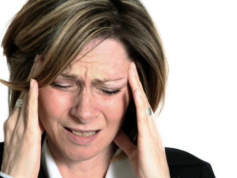 Women holding her temples with a facial expression of pain